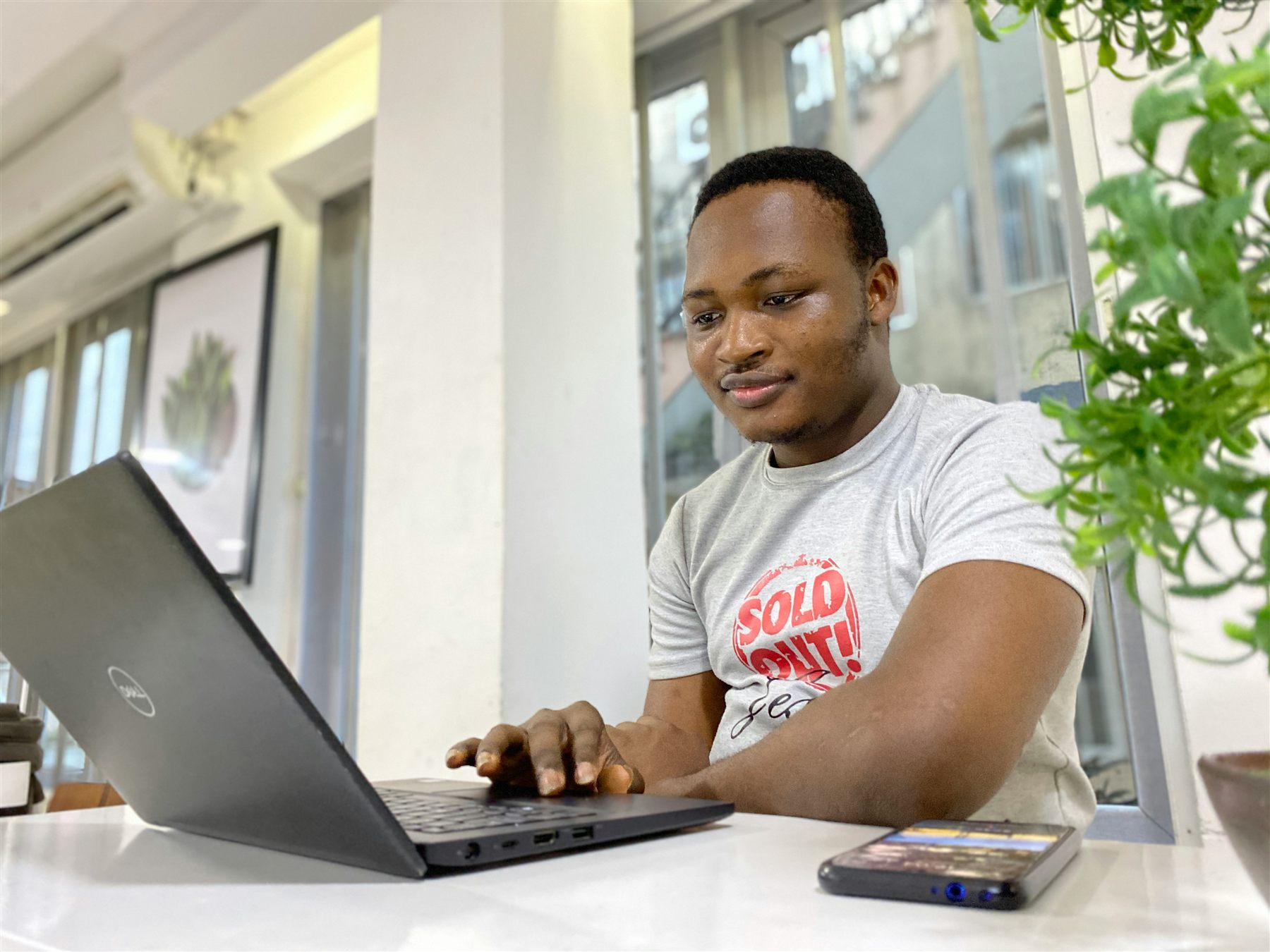 An entrepreneur working on a laptop in a bright workspace